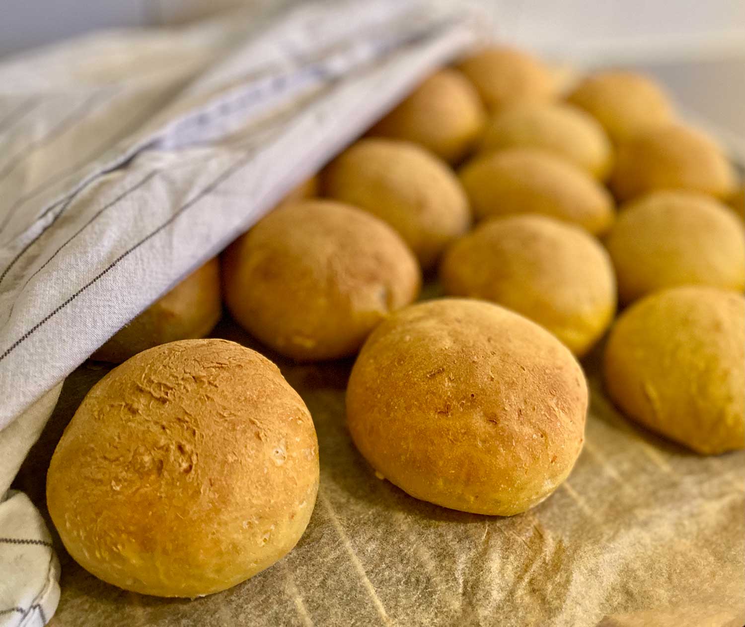 Det ligger massor av saftiga morotsfrallor och svalnar på ett bakplåtspapper med en bakduk över