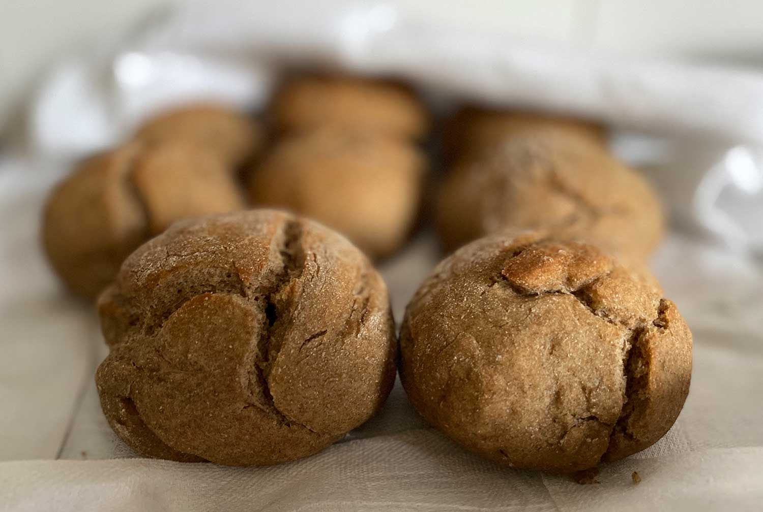 Nybakta rågbullar med sirap som ligger på en bakduk